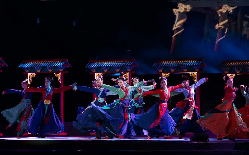Vibrant K-pop concert stage with synchronized dancers, neon lighting, and fan light sticks
